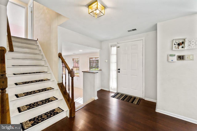 entryway featuring visible vents, stairway, baseboards, and wood finished floors