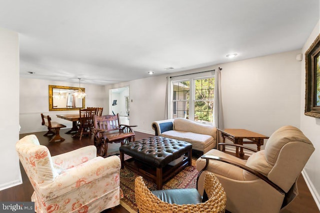 living room featuring recessed lighting, a notable chandelier, baseboards, and wood finished floors