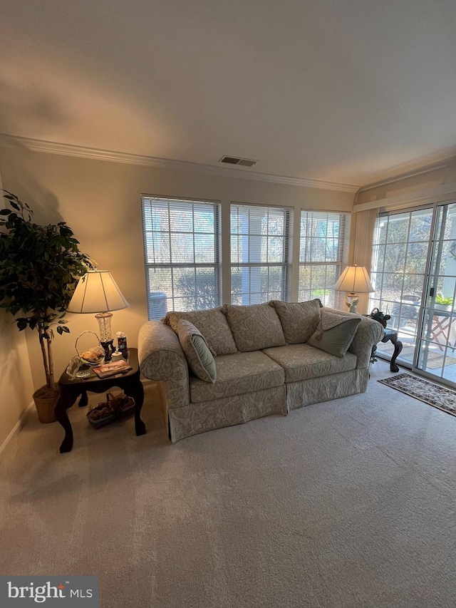 unfurnished living room with visible vents, carpet floors, and ornamental molding