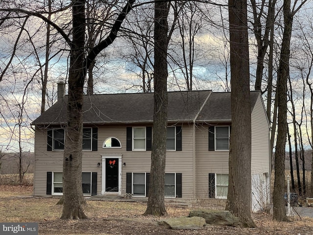 split foyer home featuring a shingled roof