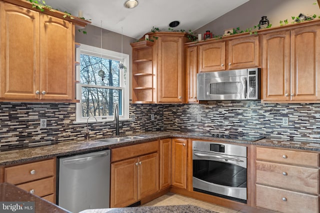 kitchen featuring dark stone counters, lofted ceiling, backsplash, and appliances with stainless steel finishes