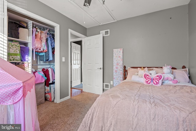 carpeted bedroom with attic access, baseboards, visible vents, and a closet