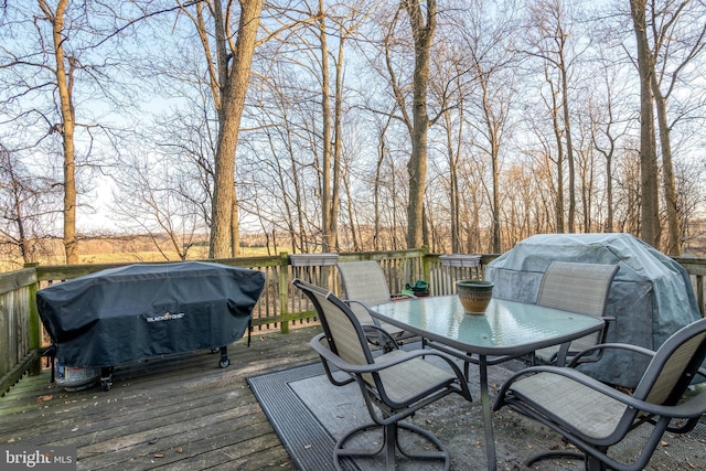 wooden deck with a grill and outdoor dining space