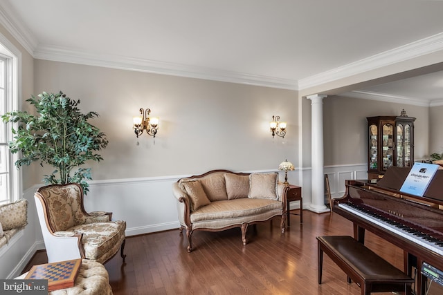 sitting room with ornate columns, crown molding, a wealth of natural light, and wood finished floors