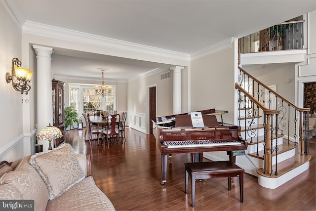 living area featuring decorative columns, visible vents, wood finished floors, and ornamental molding