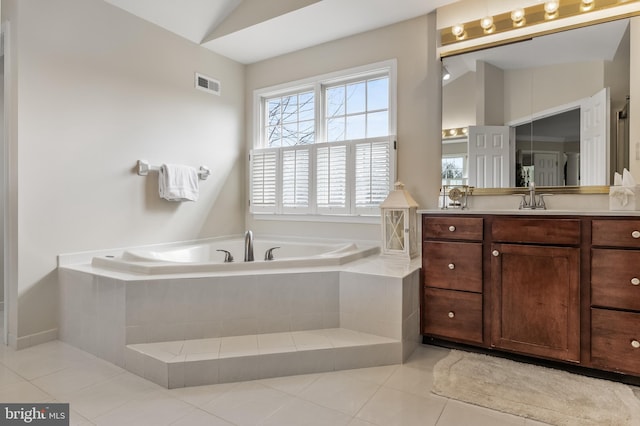 full bathroom with a garden tub, vanity, visible vents, vaulted ceiling, and tile patterned floors