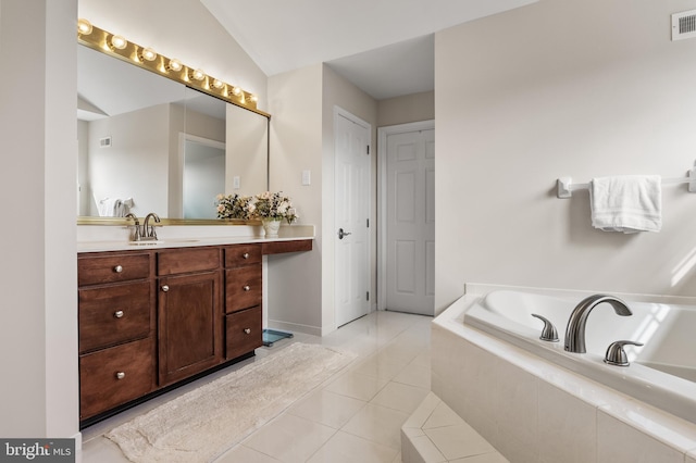 full bathroom featuring lofted ceiling, visible vents, vanity, a bath, and tile patterned floors