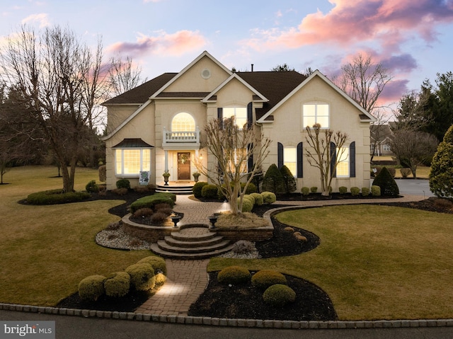 view of front facade with a yard and stucco siding