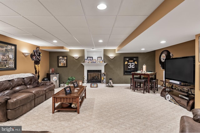 carpeted living area with a fireplace, baseboards, a drop ceiling, and recessed lighting