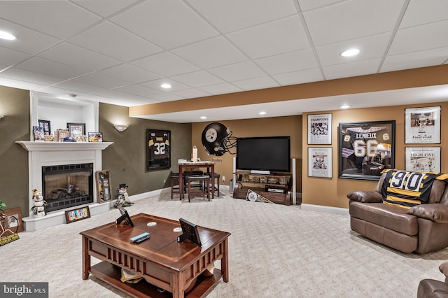 living room featuring a fireplace with raised hearth, carpet floors, baseboards, and recessed lighting