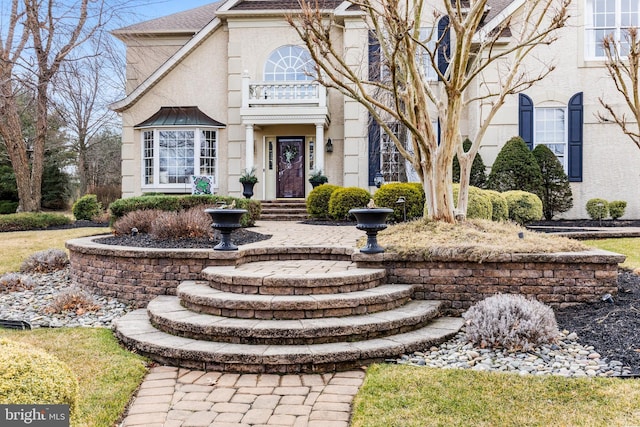 view of front facade featuring a shingled roof and stucco siding