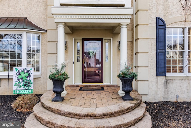 doorway to property featuring a standing seam roof and stucco siding