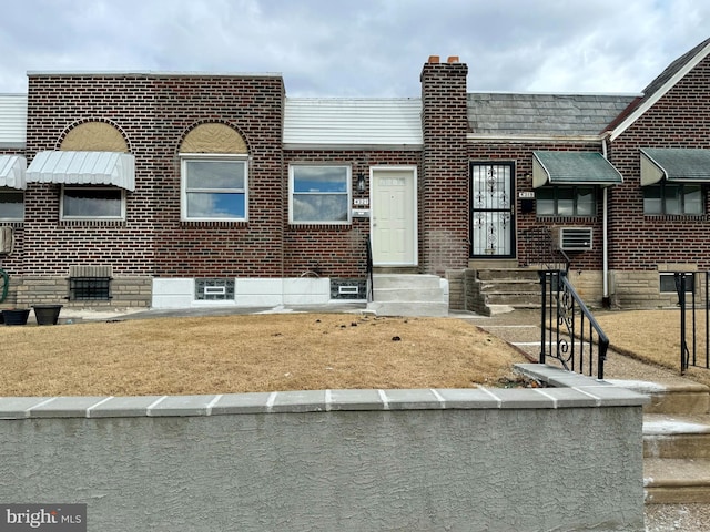 multi unit property featuring entry steps, a chimney, and brick siding