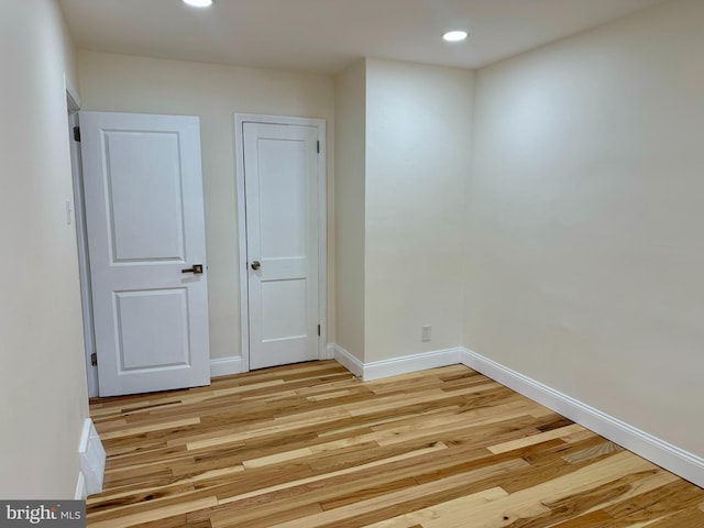 spare room featuring light wood-style floors, baseboards, and recessed lighting