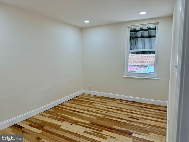 spare room with recessed lighting, baseboards, and wood finished floors