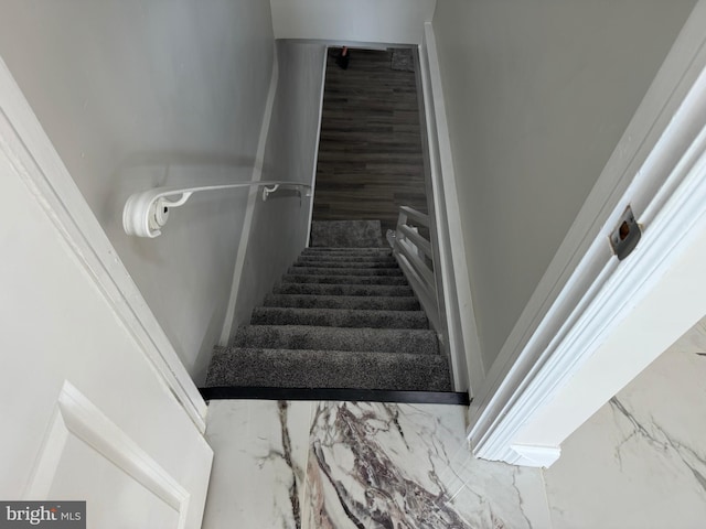 stairway featuring marble finish floor