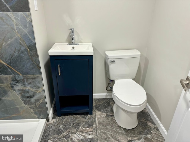 bathroom with marble finish floor, vanity, toilet, and baseboards