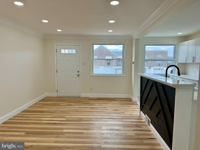 interior space featuring crown molding, recessed lighting, baseboards, and light wood-style floors