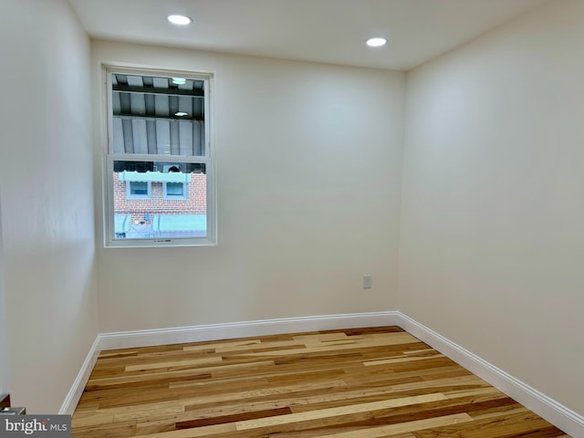 spare room with light wood-type flooring, baseboards, and recessed lighting