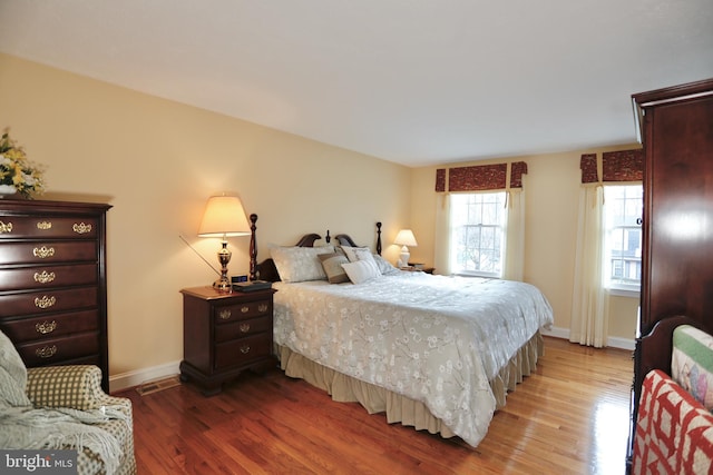 bedroom featuring light wood finished floors and baseboards