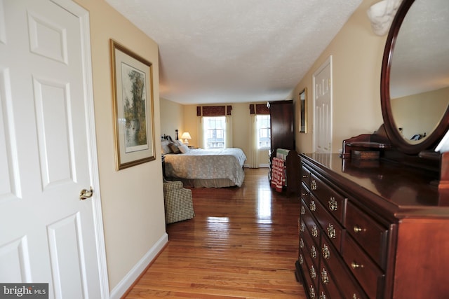 bedroom with baseboards and wood finished floors