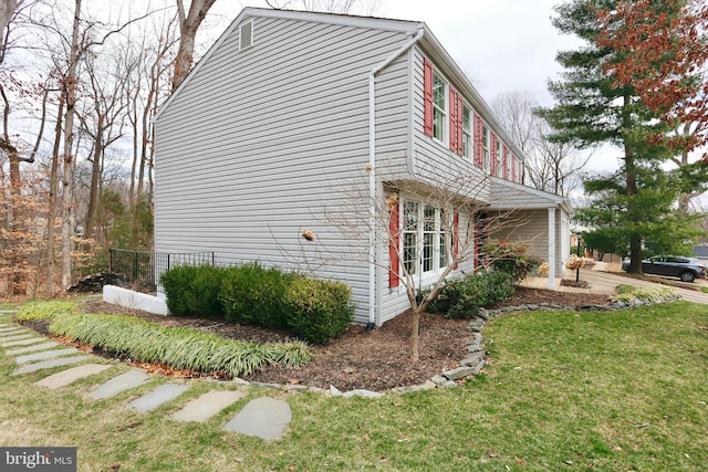 view of side of home with a yard