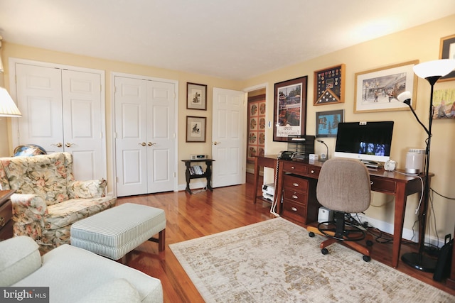 home office featuring baseboards and wood finished floors