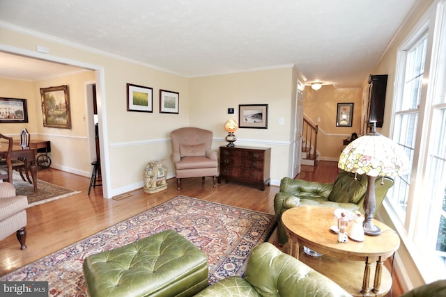 living area with stairway, wood finished floors, and crown molding