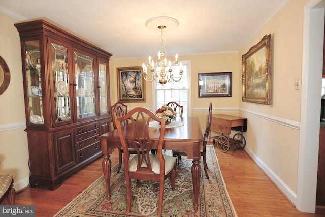 dining area with crown molding, baseboards, and wood finished floors