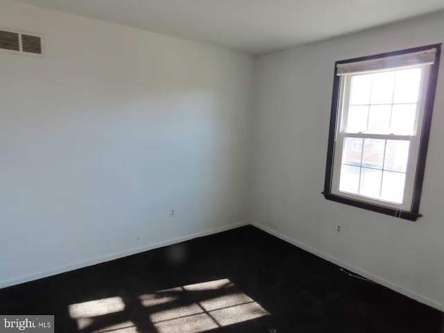 empty room featuring baseboards and visible vents