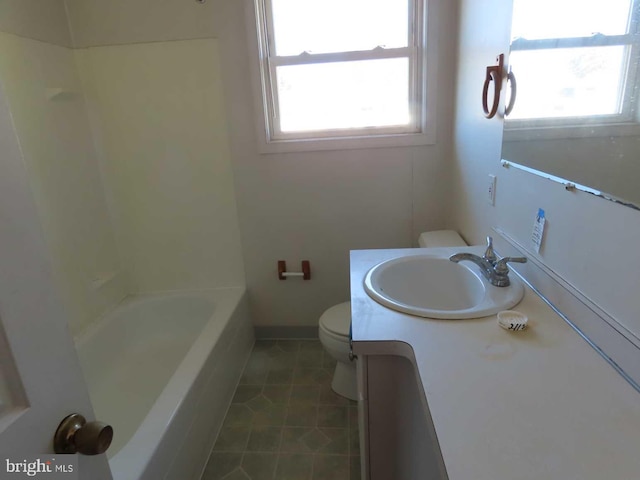 bathroom with toilet, tile patterned flooring, a wealth of natural light, and vanity