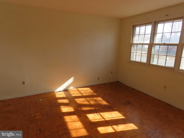 unfurnished room with visible vents and baseboards