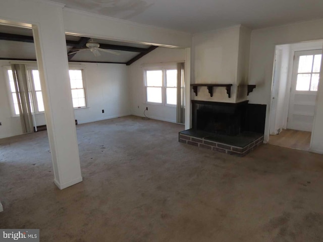 unfurnished living room featuring plenty of natural light, ceiling fan, carpet, and a brick fireplace