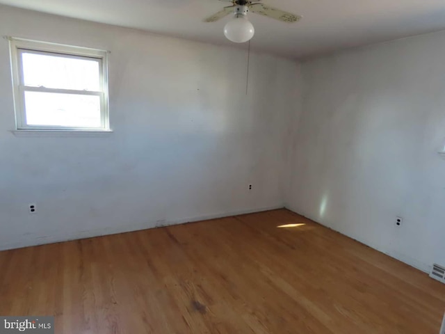 unfurnished room with light wood-type flooring, visible vents, and ceiling fan