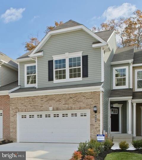 view of front of property featuring brick siding, driveway, and an attached garage