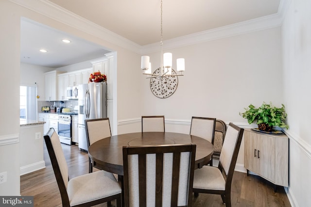 dining room featuring crown molding, a chandelier, and dark wood finished floors