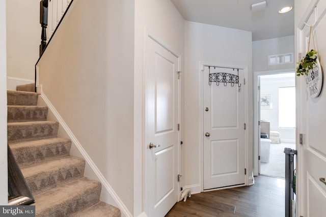 interior space featuring visible vents, dark wood finished floors, stairway, and baseboards