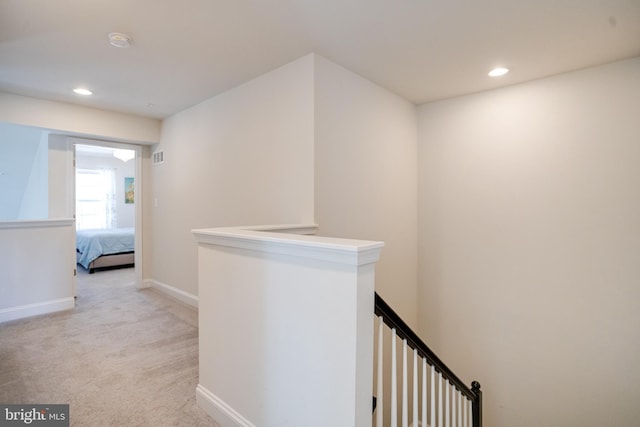 hallway featuring light carpet, recessed lighting, an upstairs landing, and baseboards