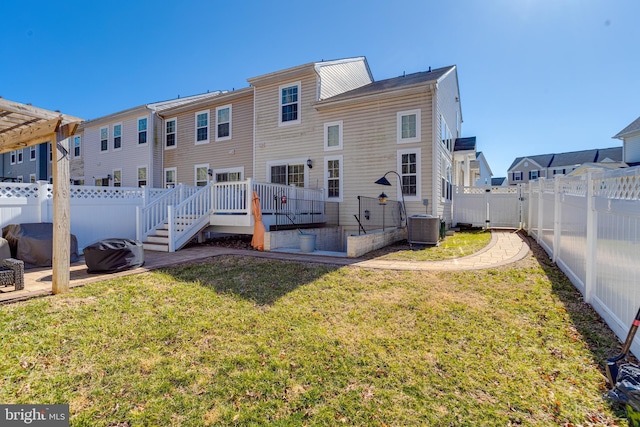 rear view of house with a lawn, a fenced backyard, a residential view, cooling unit, and a wooden deck