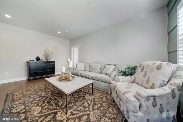 living area with baseboards, wood finished floors, and recessed lighting