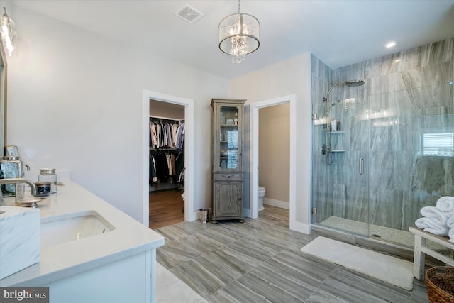 full bath with visible vents, toilet, a shower stall, a chandelier, and a sink