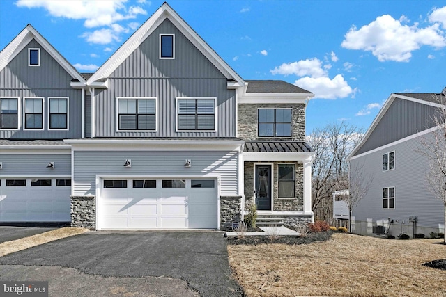 view of front of house featuring stone siding, driveway, and an attached garage