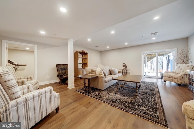 living room with recessed lighting, visible vents, and wood finished floors