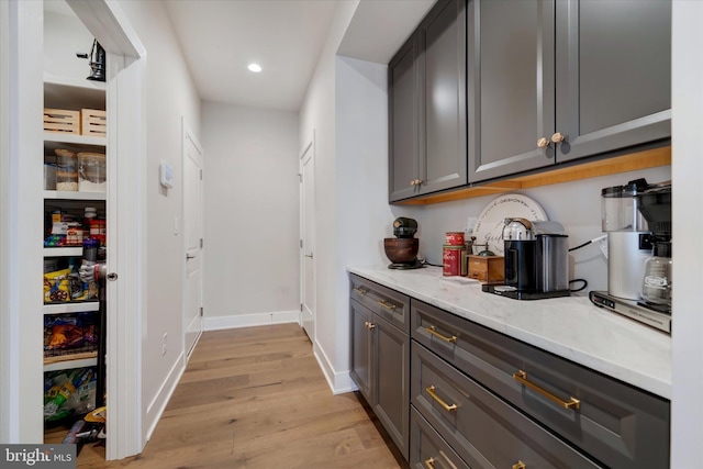 bar with baseboards, recessed lighting, and light wood-style floors