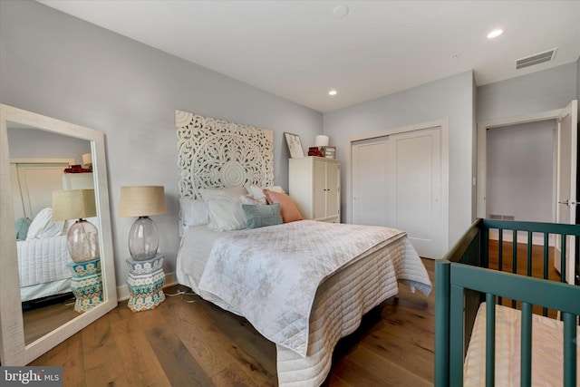 bedroom with baseboards, visible vents, dark wood finished floors, a closet, and recessed lighting