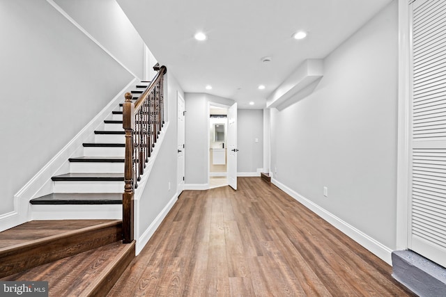 entrance foyer featuring baseboards, stairway, wood finished floors, and recessed lighting