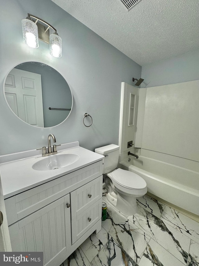 bathroom featuring a textured ceiling, marble finish floor, toilet, and vanity