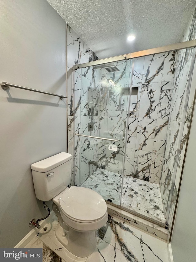 full bathroom with toilet, marble finish floor, a marble finish shower, and a textured ceiling