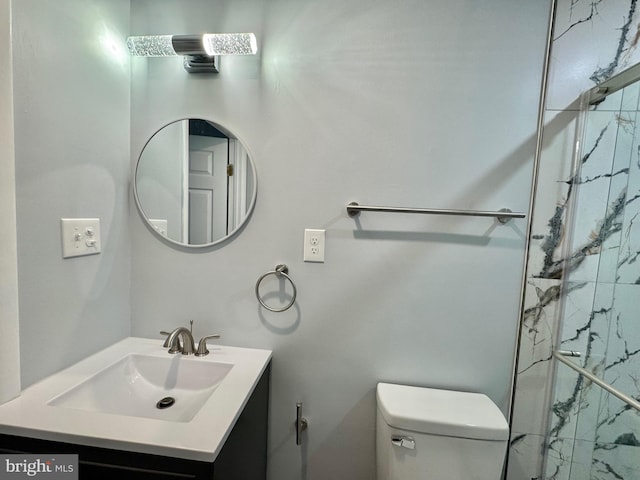 bathroom with vanity, a marble finish shower, and toilet