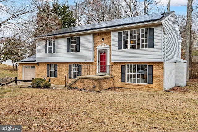 bi-level home with roof mounted solar panels and brick siding